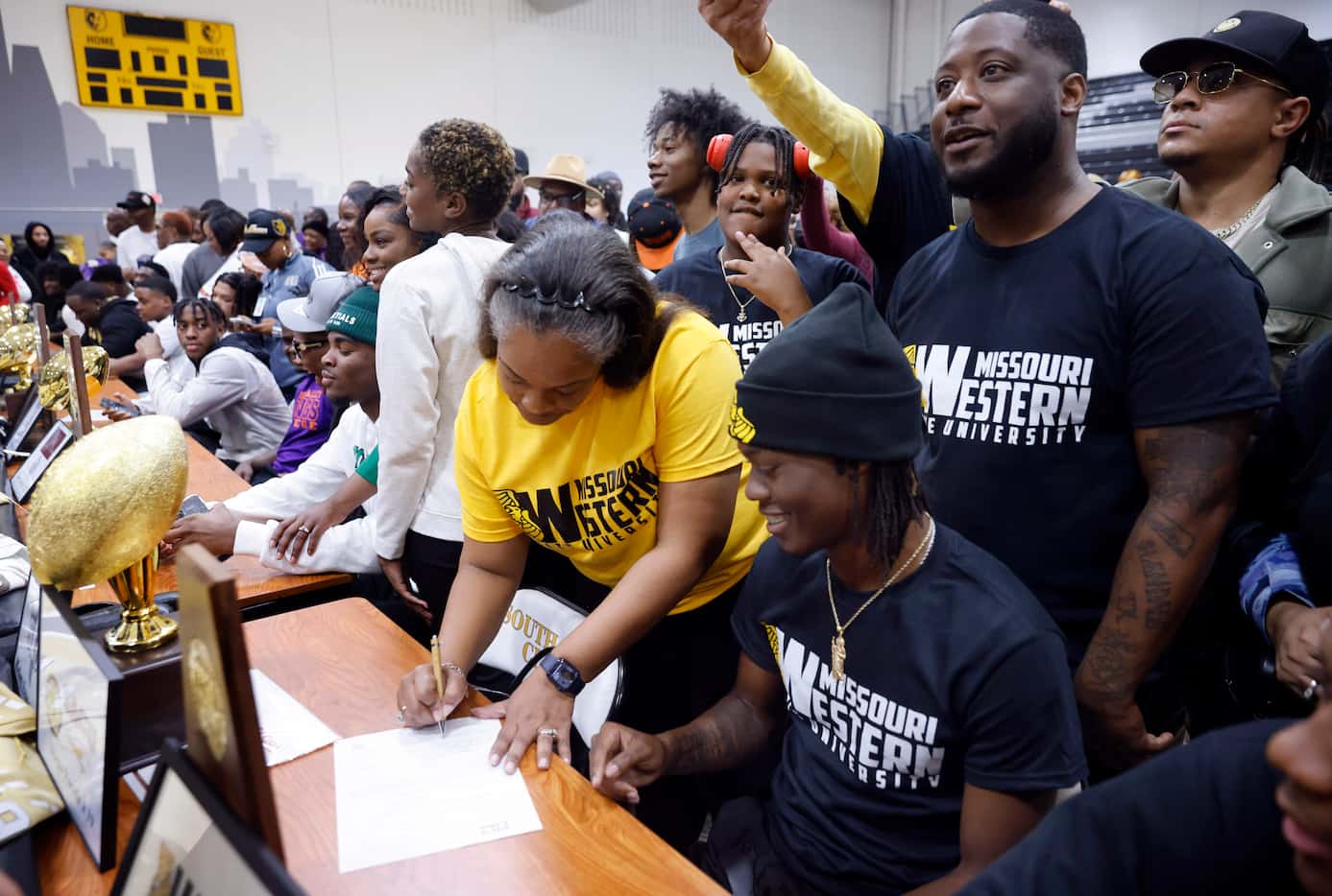 South Oak Cliff football player Daveon Ennis (seated) and his mother LaShema Thibodeaux ...