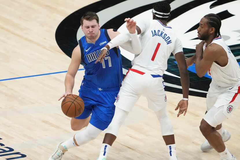 Dallas Mavericks guard Luka Doncic (77) tries to fight his way past LA Clippers guard Reggie...