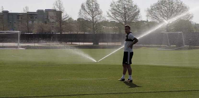 Reto Ziegler waits on the sprinklers at FC Dallas training. (4-11-18)