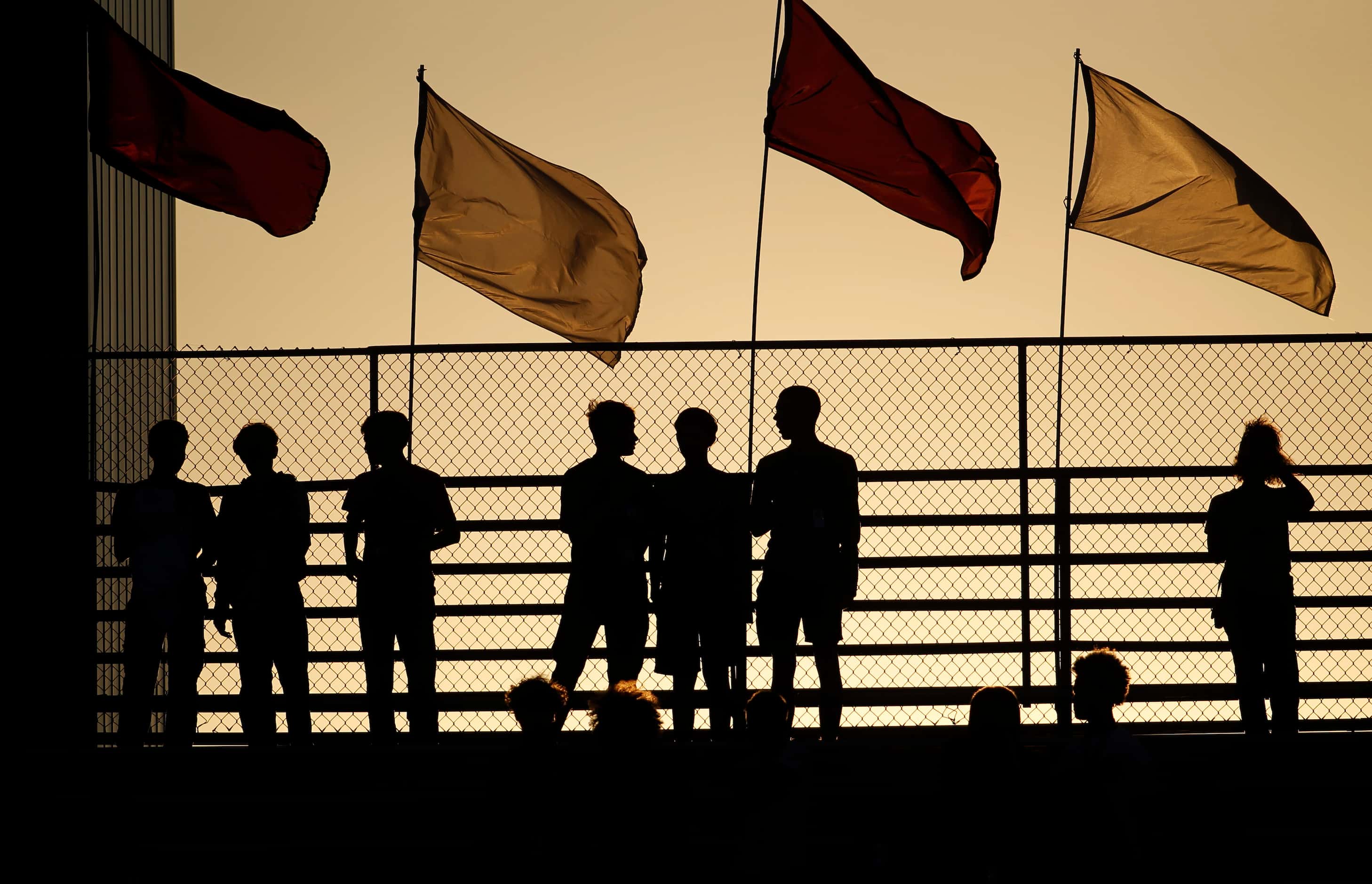 Lewisville fans are silhouetted against a setting sun just prior to the opening kickoff as...