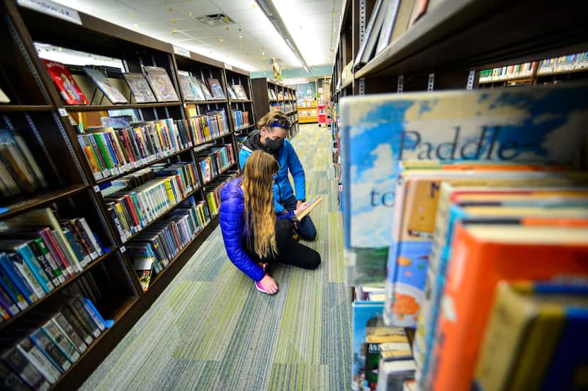 People select a library book in this file photo. The Keller Public Library recently decided...