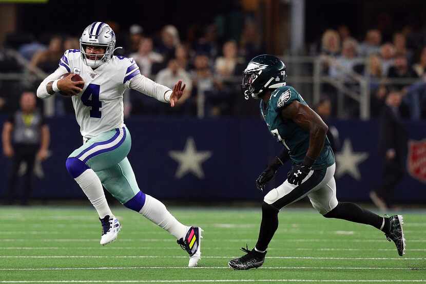 El mariscal de los Dallas Cowboys, Dak Prescott, se quita la presión de un defensivo de los...