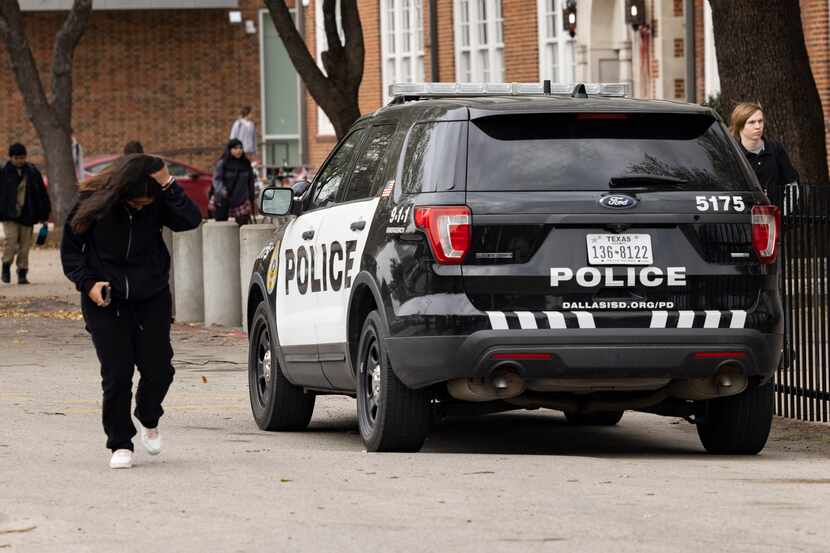 Students walked past a DISD police cruiser during the school’s dismissal at Woodrow Wilson...