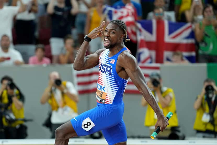 Noah Lyles, from the United States, gestures after crossing the finish line to win the gold...