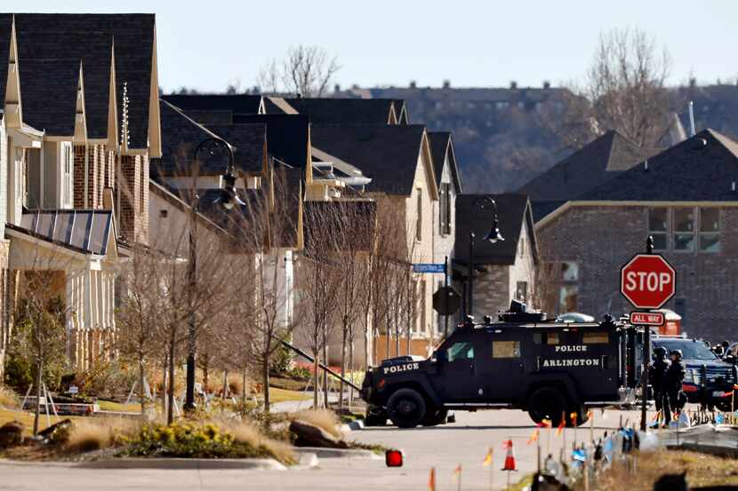Arlington Police tactical officers aim their armored vehicle at a home where a man...