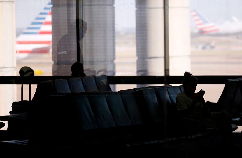 Passengers wait at a gate in Terminal C at DFW International Airport on Monday, November 16,...