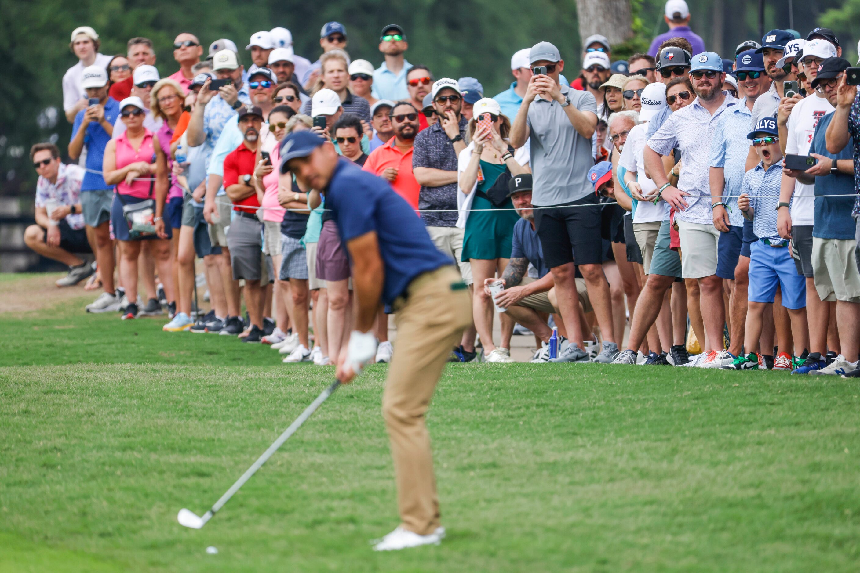 People watch as Jason Day sets to hit on the green of the ninth hole during the second round...