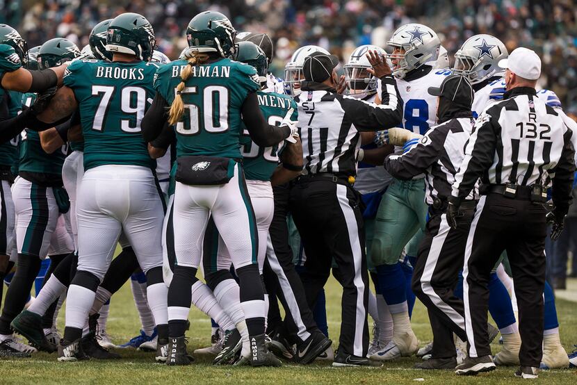 Officials try to separate Philadelphia Eagles and Dallas Cowboys players as they scuffle...