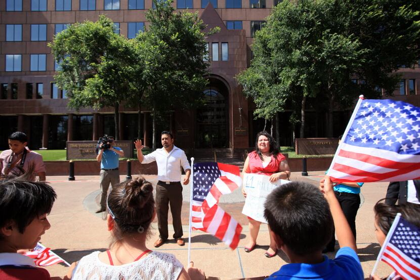  Ramiro Luna, left,  and Greisa Martinez, immigrant leaders,  lead chants outside the office...