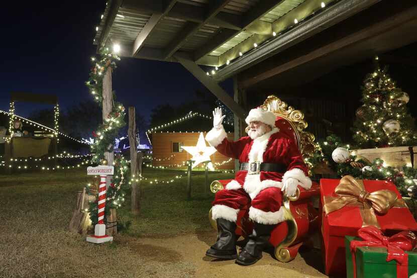 Doug Goodrich performs as Santa Claus during the holiday lights display and fair at Heritage...