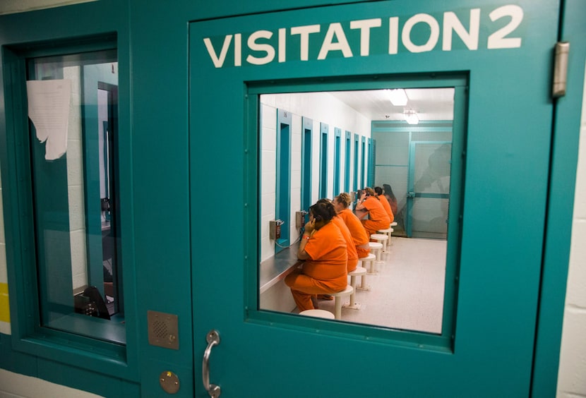 Female inmates talk to visitors through glass in October at Burnet County Jail. The jail...