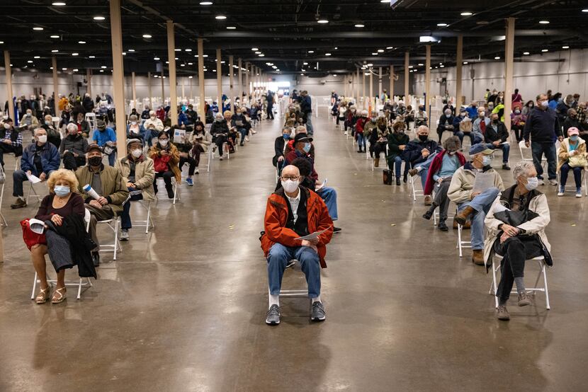 People wait to receive the COVID-19 vaccine at Fair Park in Dallas on Thursday, Jan. 14,...