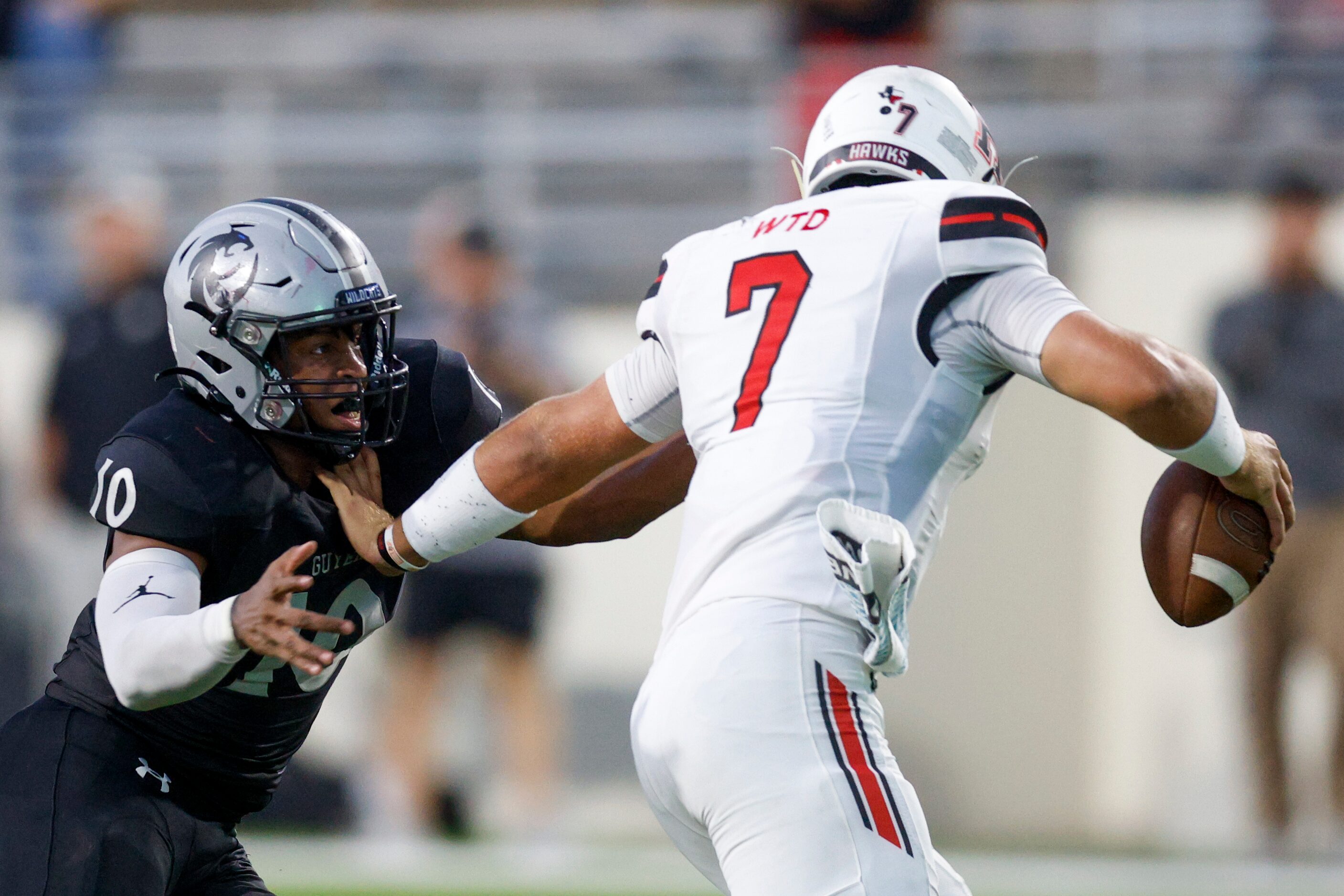 Rockwall-Heath quarterback Caleb Hoover (7) stiff-arms Denton Guyer linebacker Caleb...