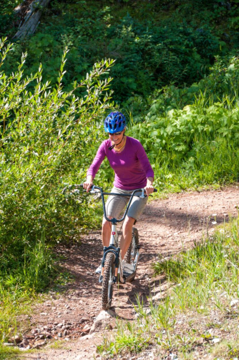 A woman tackles Purgatory's Diggler trail.  Like top-end mountain bikes, these scooters...