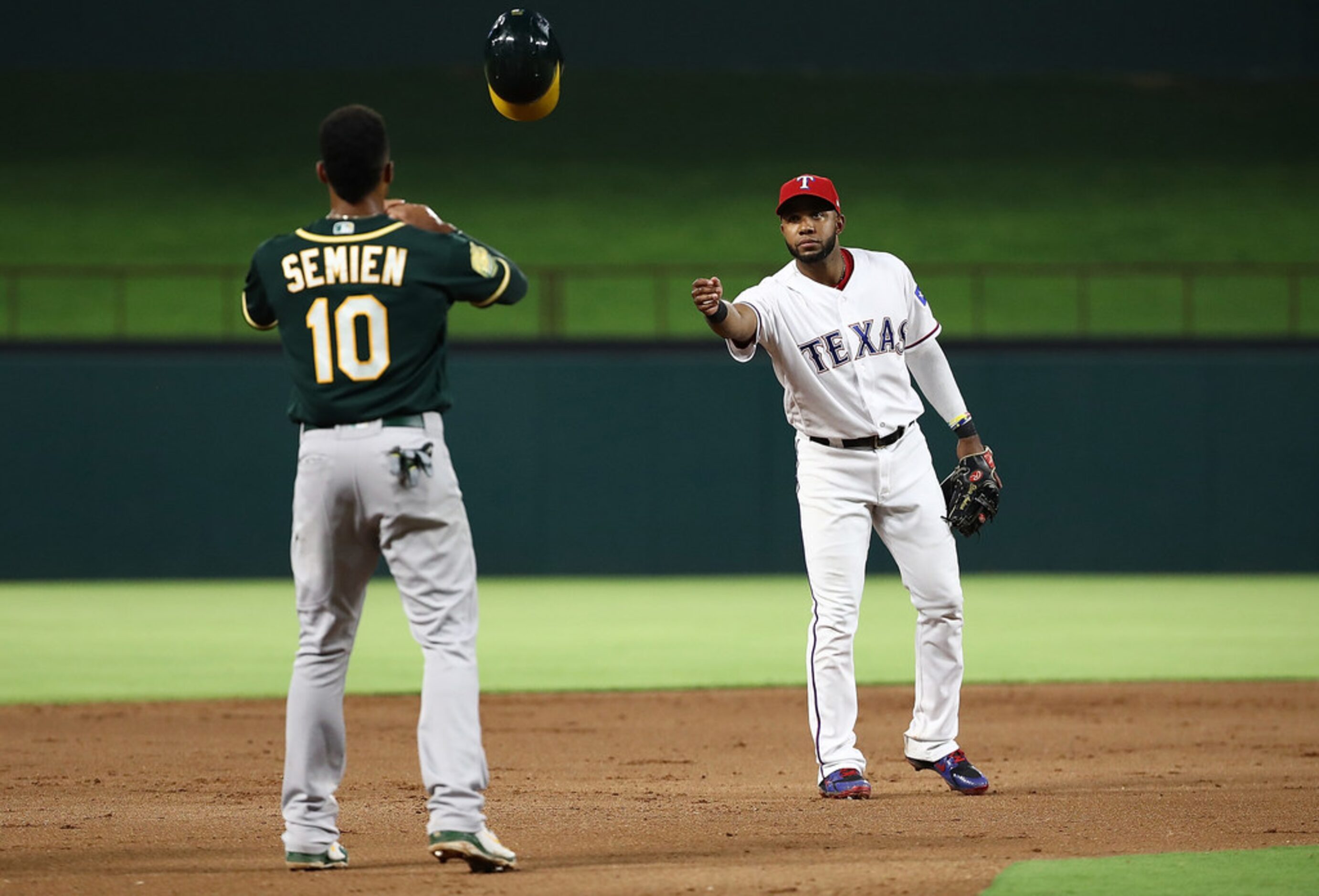 ARLINGTON, TX - JULY 25:  Elvis Andrus #1 of the Texas Rangers throws the batting helmet to...