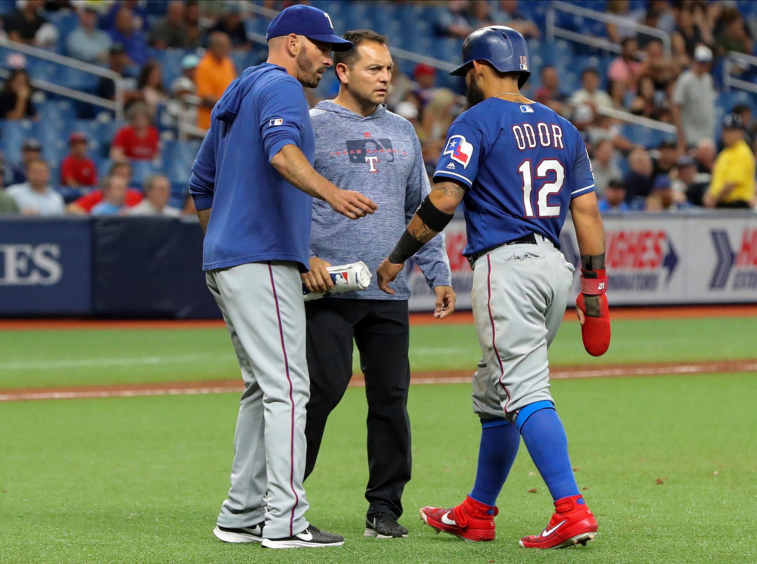 Texas Rangers manager Chris Woodward, left, and head athletic trainer Matt Lucero attend to...