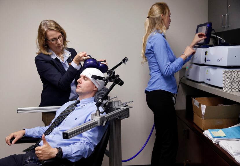 Lab manager Ellen Morris adjusts a rTMS (repetitive Transcranial Magnetic Stimulation)...