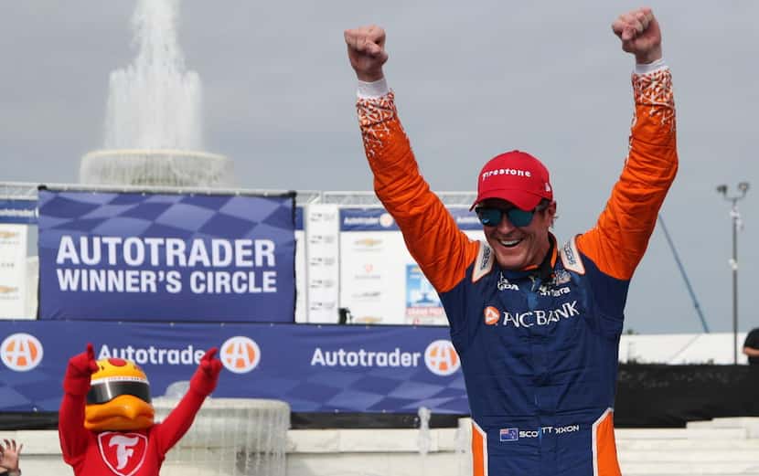 Scott Dixon celebrates as he exits his car after winning the first race of the IndyCar...