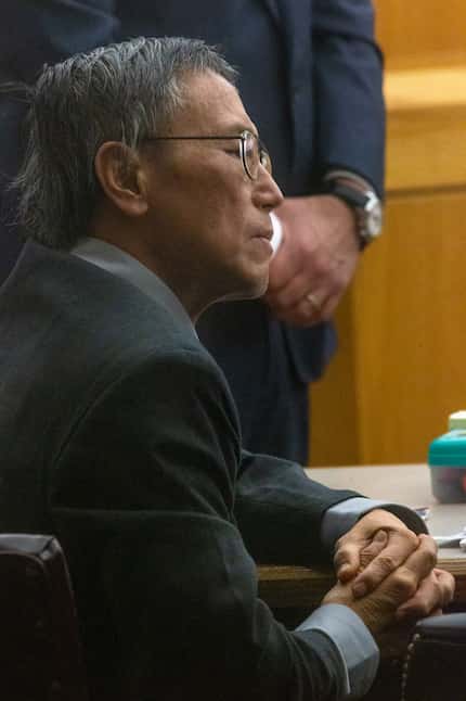 Former doctor and convicted sexual predator George Guo looks over at crime scene photographs...