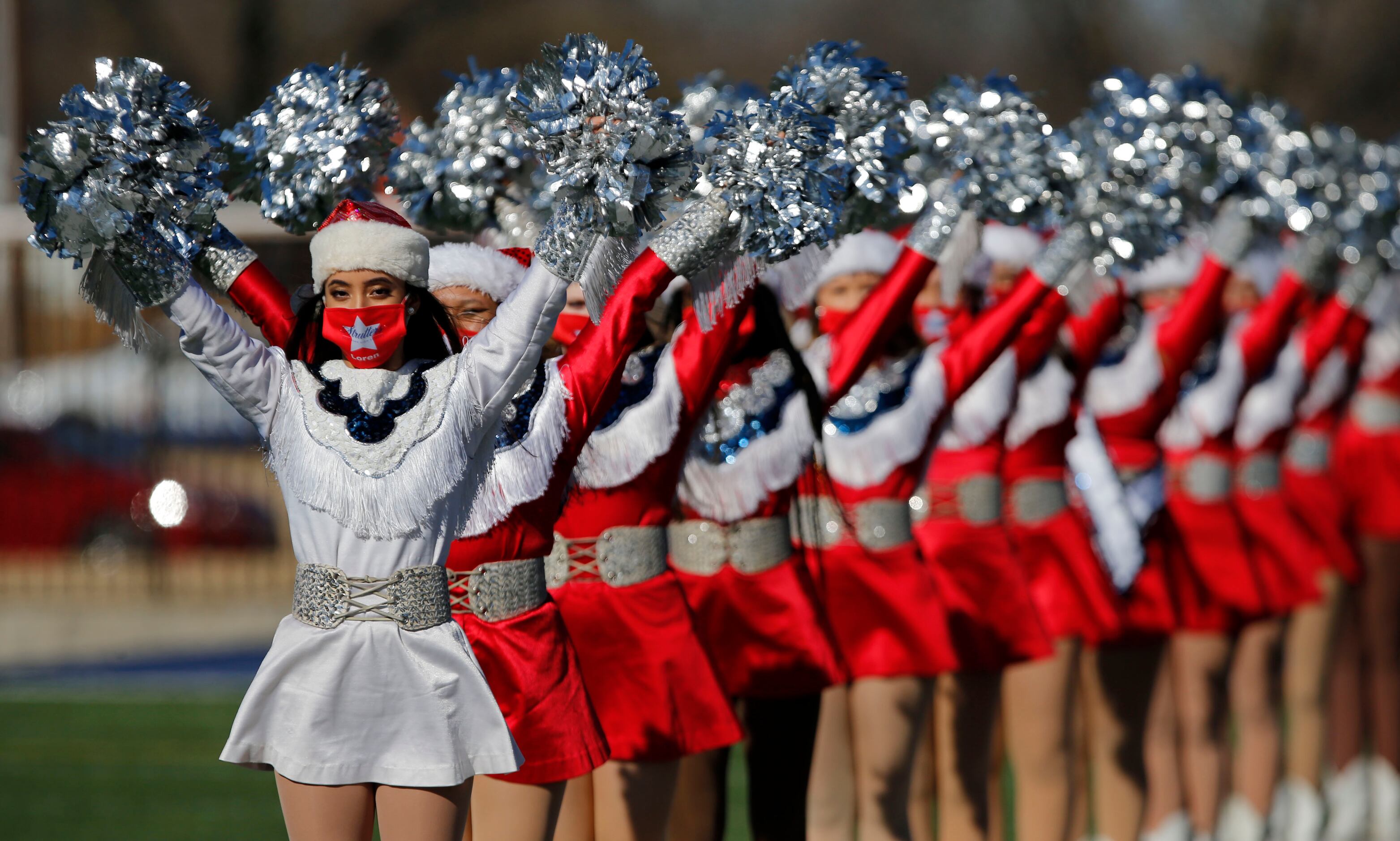 The Denton Ryan drill team is still dressed in festive Christmas attire on the field before...