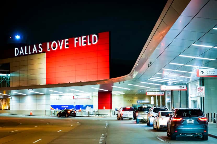 Cars pull up to the lightly trafficked departures curbside in front of Dallas Love Field...