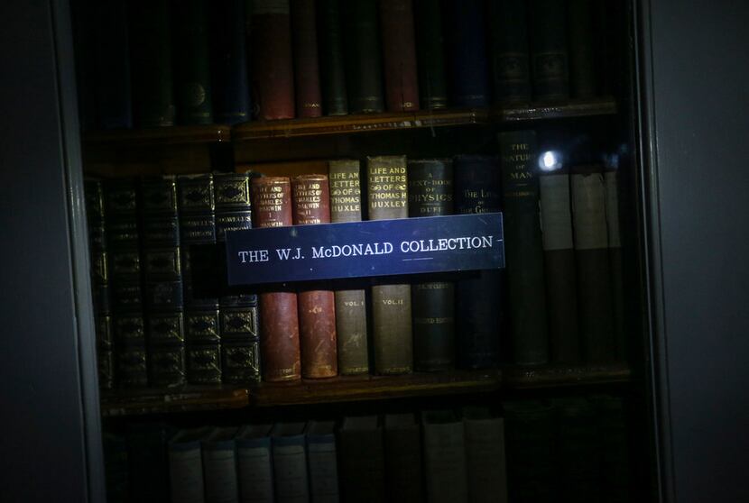 Books from the original W.J. McDonald Collection are illuminated by a flashlight at McDonald...