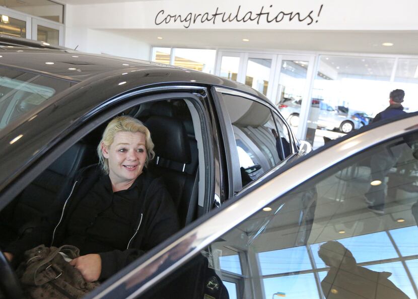 Christal Scott reacts to receiving a 2012 Honda Accord at Ewing Buick-GMC dealership in...