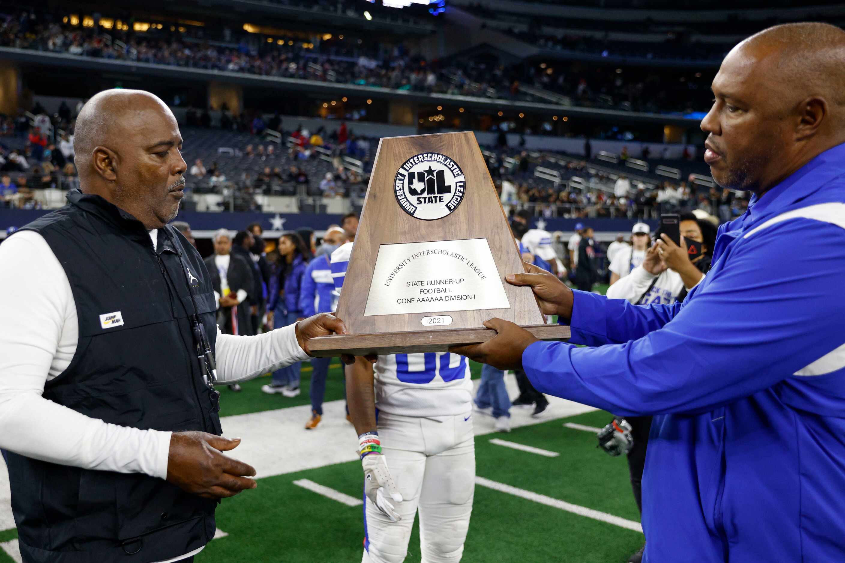 Duncanville ISD athletic director Dwight Weaver presents Duncanville head coach Reginald...