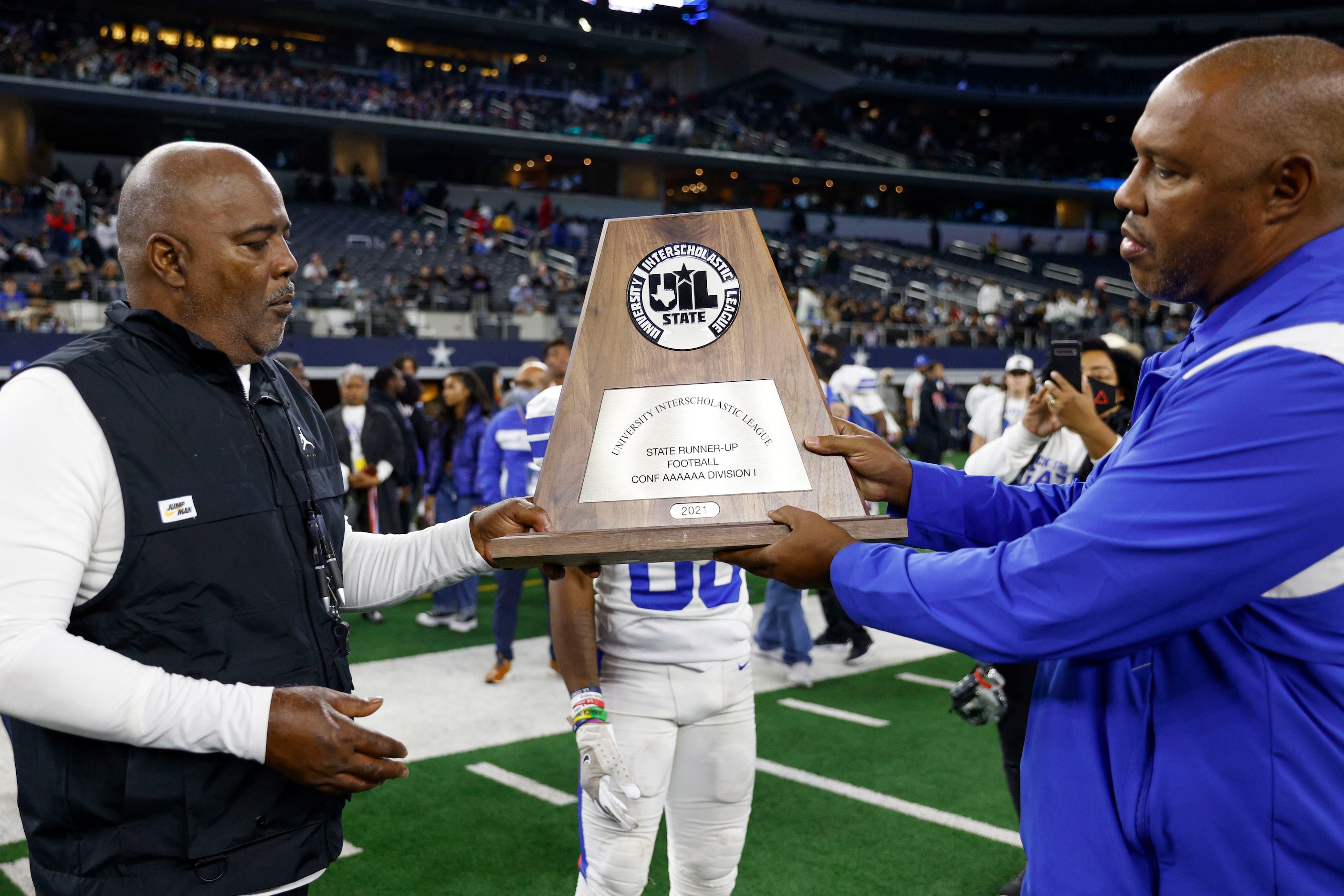 Duncanville ISD athletic director Dwight Weaver presents Duncanville head coach Reginald...