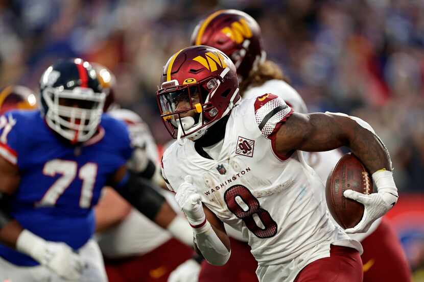 Washington Commanders running back Brian Robinson Jr. (8) runs with the ball against the New...