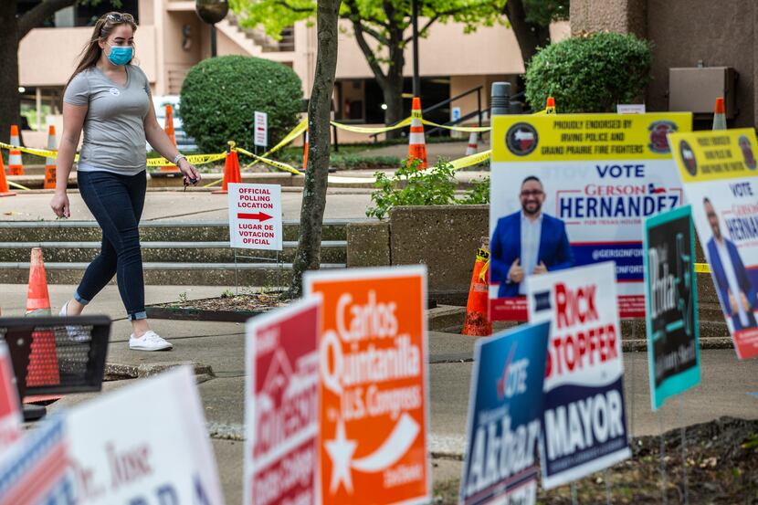 Alyse Brown walks past campaign signs after casting a ballot during the general election...