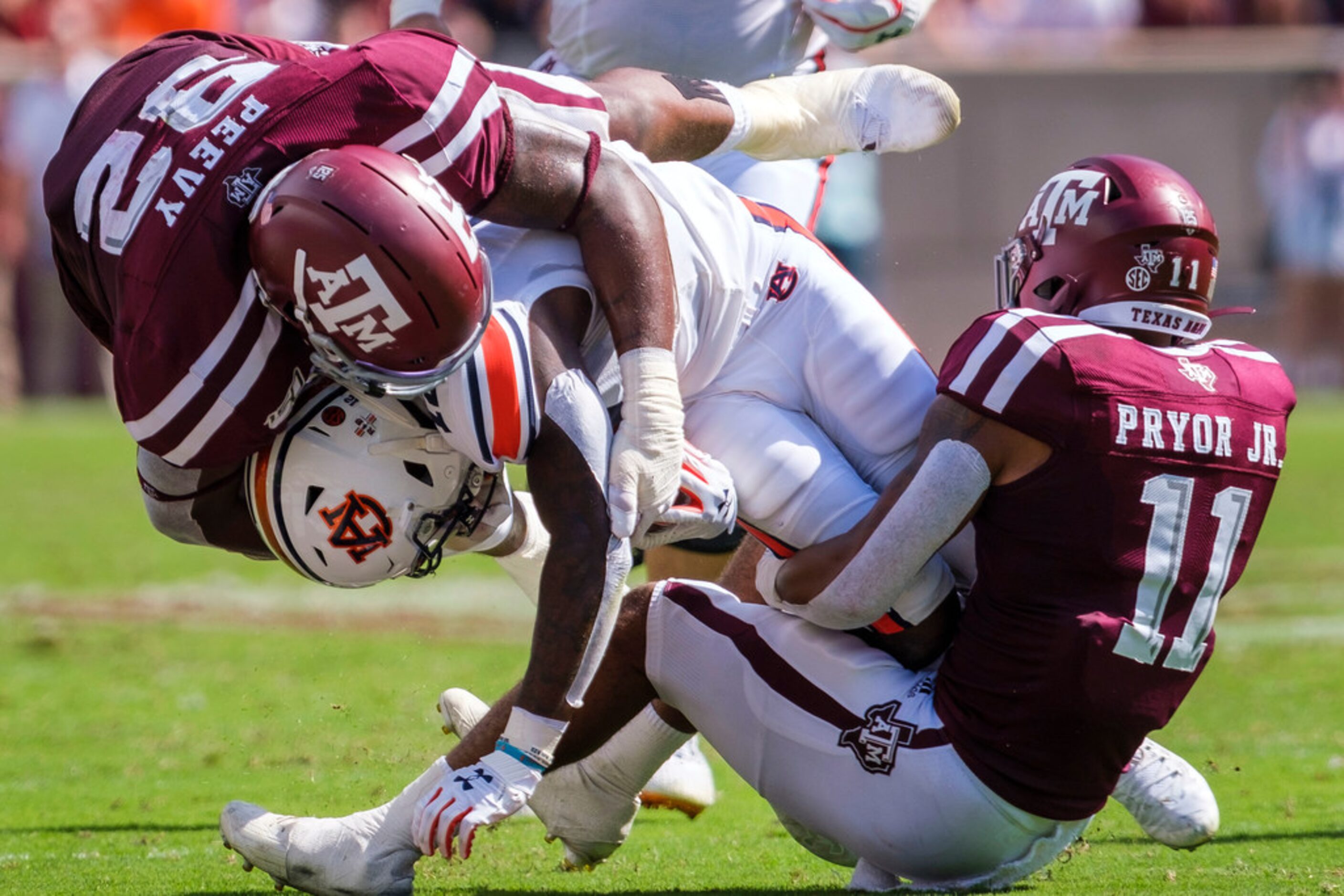 Auburn wide receiver Eli Stove (12) is brought down by Texas A&M defensive back Larry Pryor...