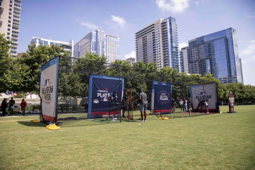 People use a batting cage as MLB and the Texas Rangers host a sneak preview of the MLB...