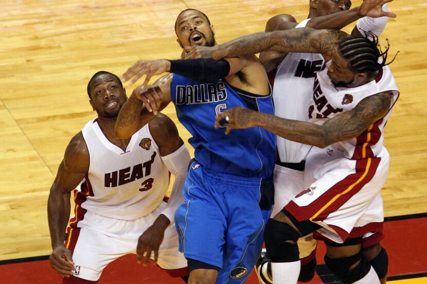 Dallas Mavericks center Tyson Chandler (6) hits the ball towards a teammate as Miami Heat...