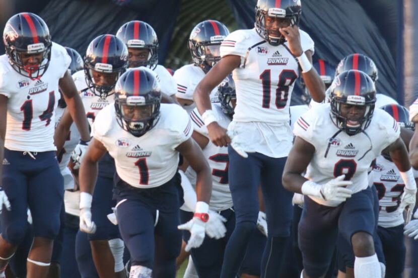 Members of the Bishop Dunne Falcons football team race onto the field just prior to the...