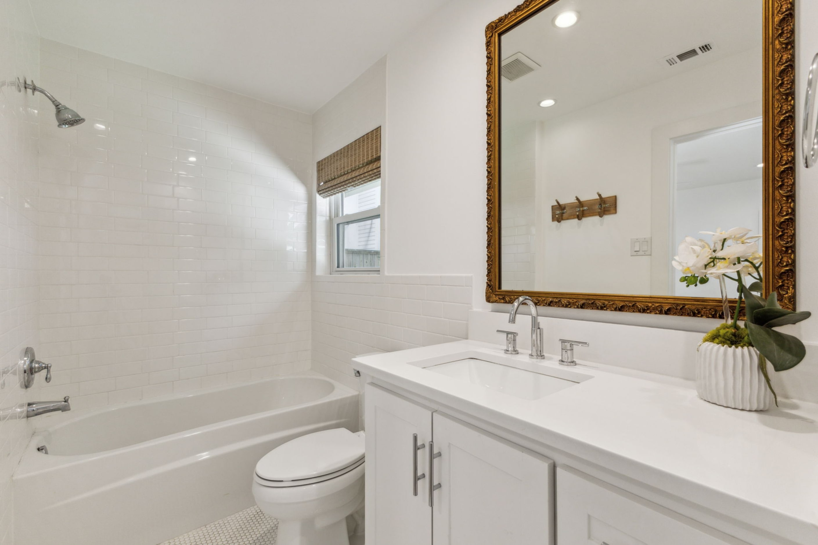 One of the bathrooms has this classic design with white subway tile and cabinetry.