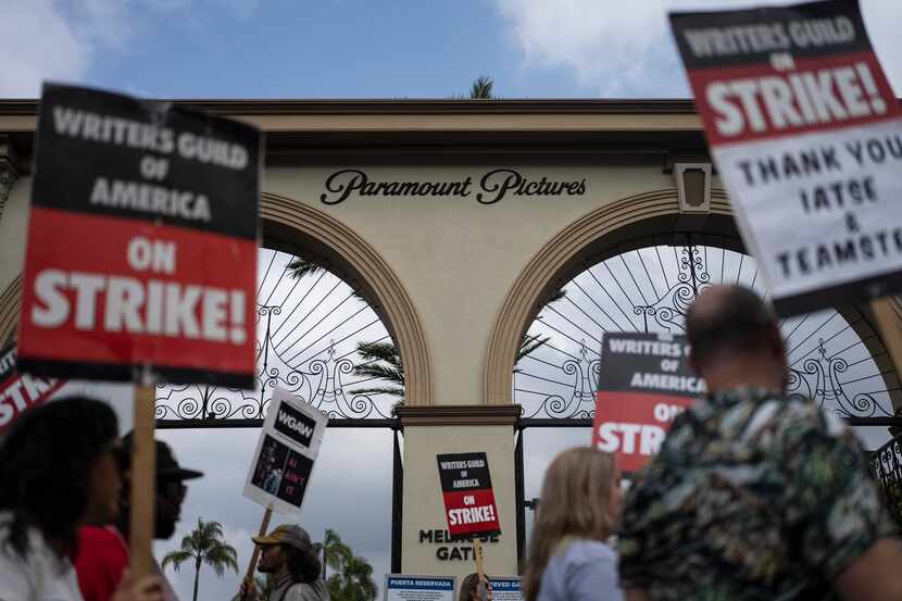 FILE - Demonstrators walk with signs during a rally outside the Paramount Pictures Studio in...