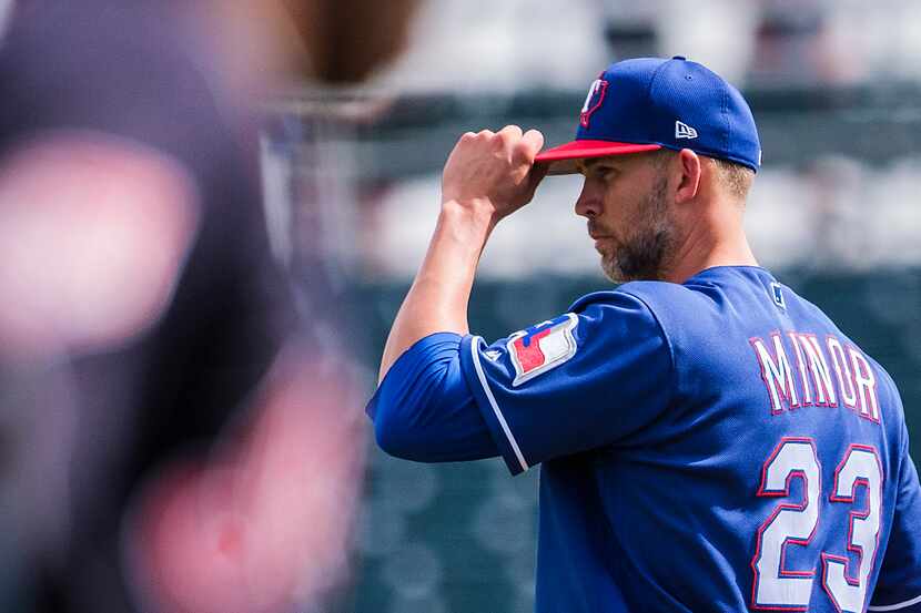 Texas Rangers pitcher Mike Minor adjusts his cap as Cleveland Indians center fielder Greg...