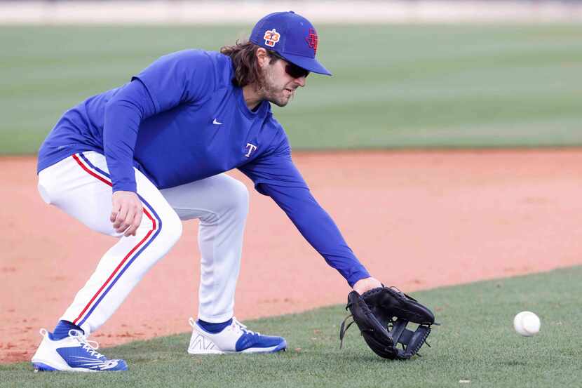 Texas Rangers infielder Josh Smith takes part in a fielding drill during a spring training...