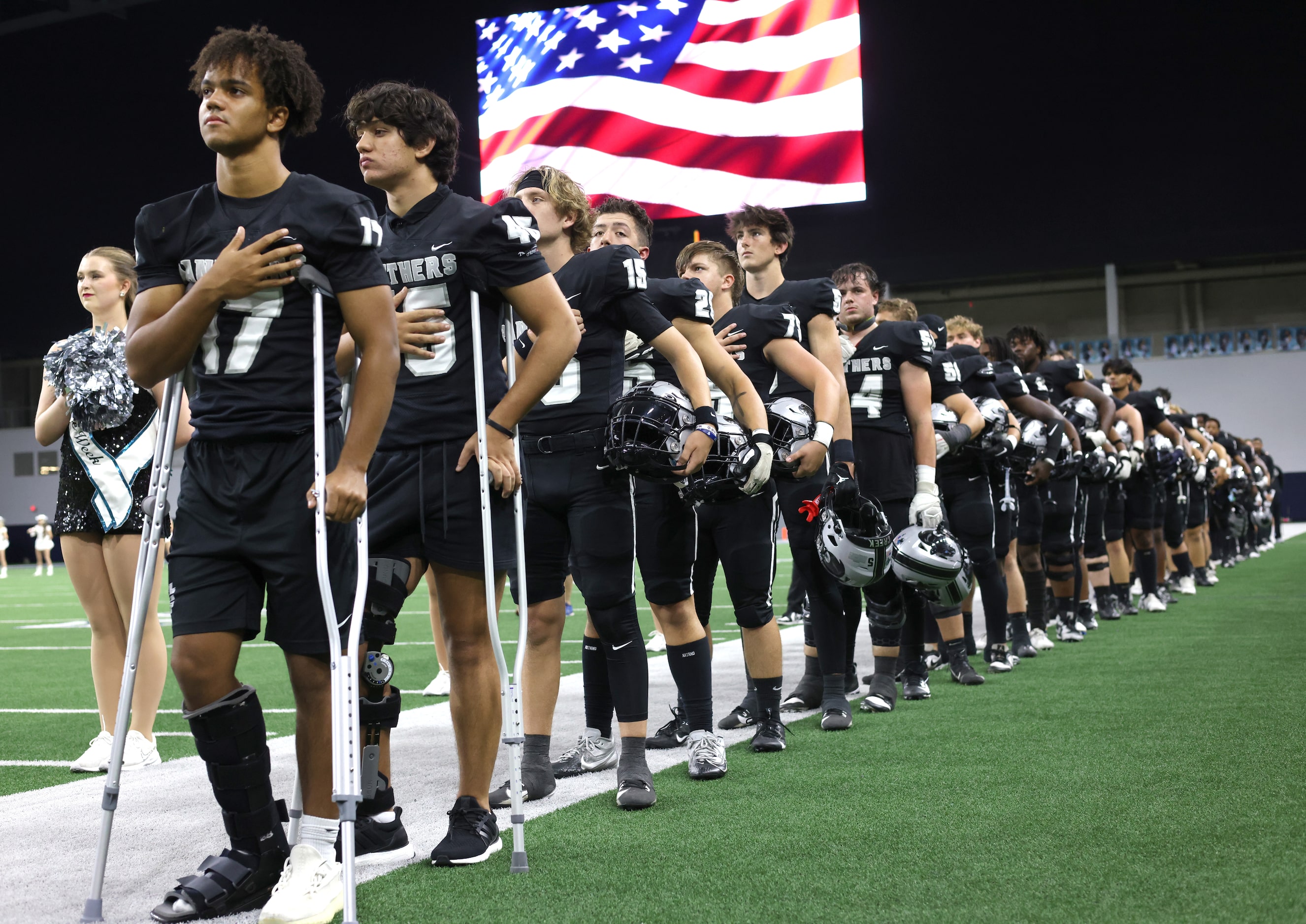 Frisco Panther Creek players pause for the playing of the national anthem prior to the...