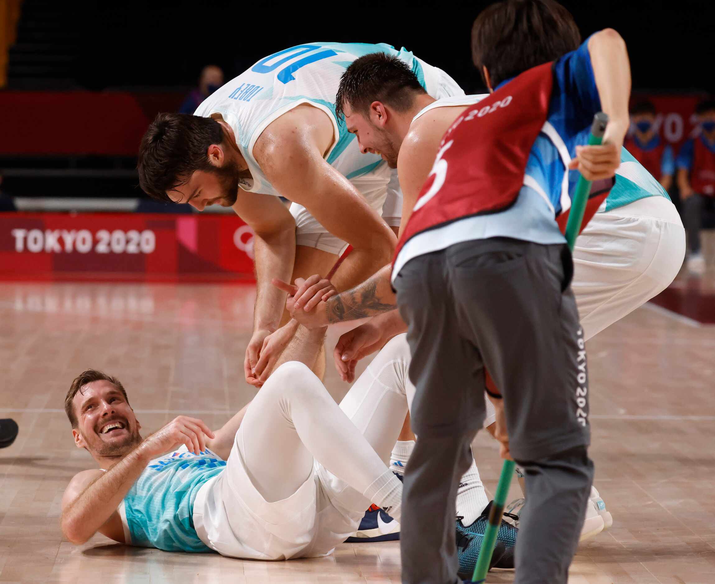 Slovenia’s Zoran Dragic (30) laughs as Mike Tobey (10) and Luka Doncic (77) help him up...