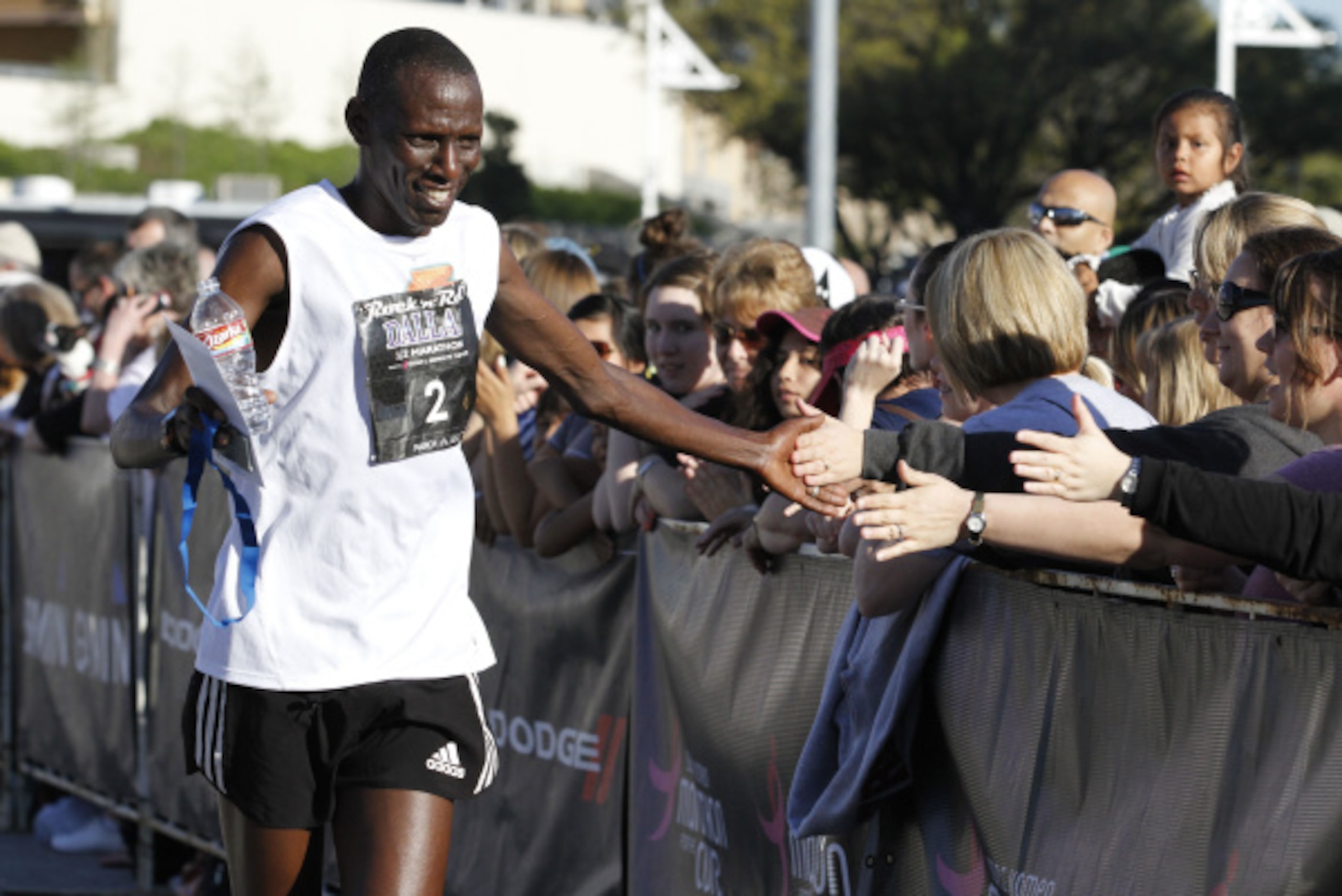 Sammy Kiplagat high-fives spectators after finishing the Dallas Rock 'N' Roll half marathon...