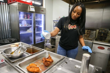 Carlonda Marshall of 2Neighbors Hot Chicken seasons chicken in DeSoto in late 2020.