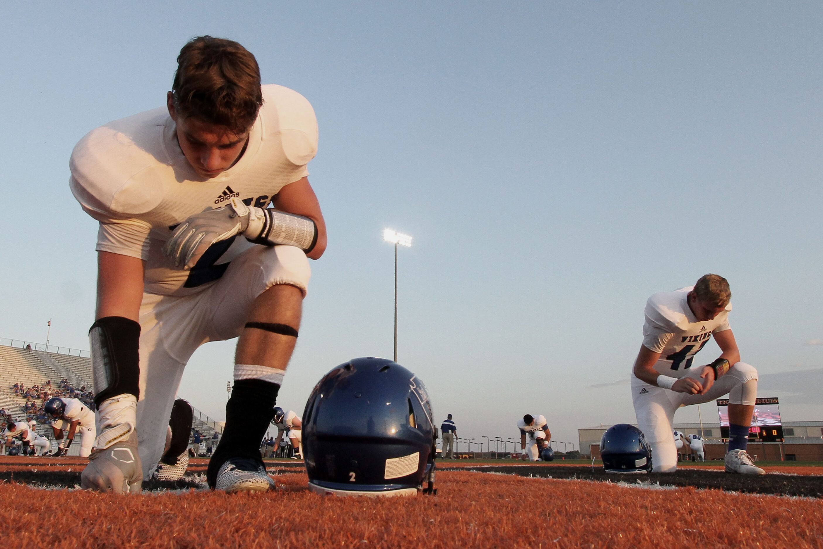 Fort Worth Nolan defensive back Travis Moore (2) pauses with other teammates for a prayer...