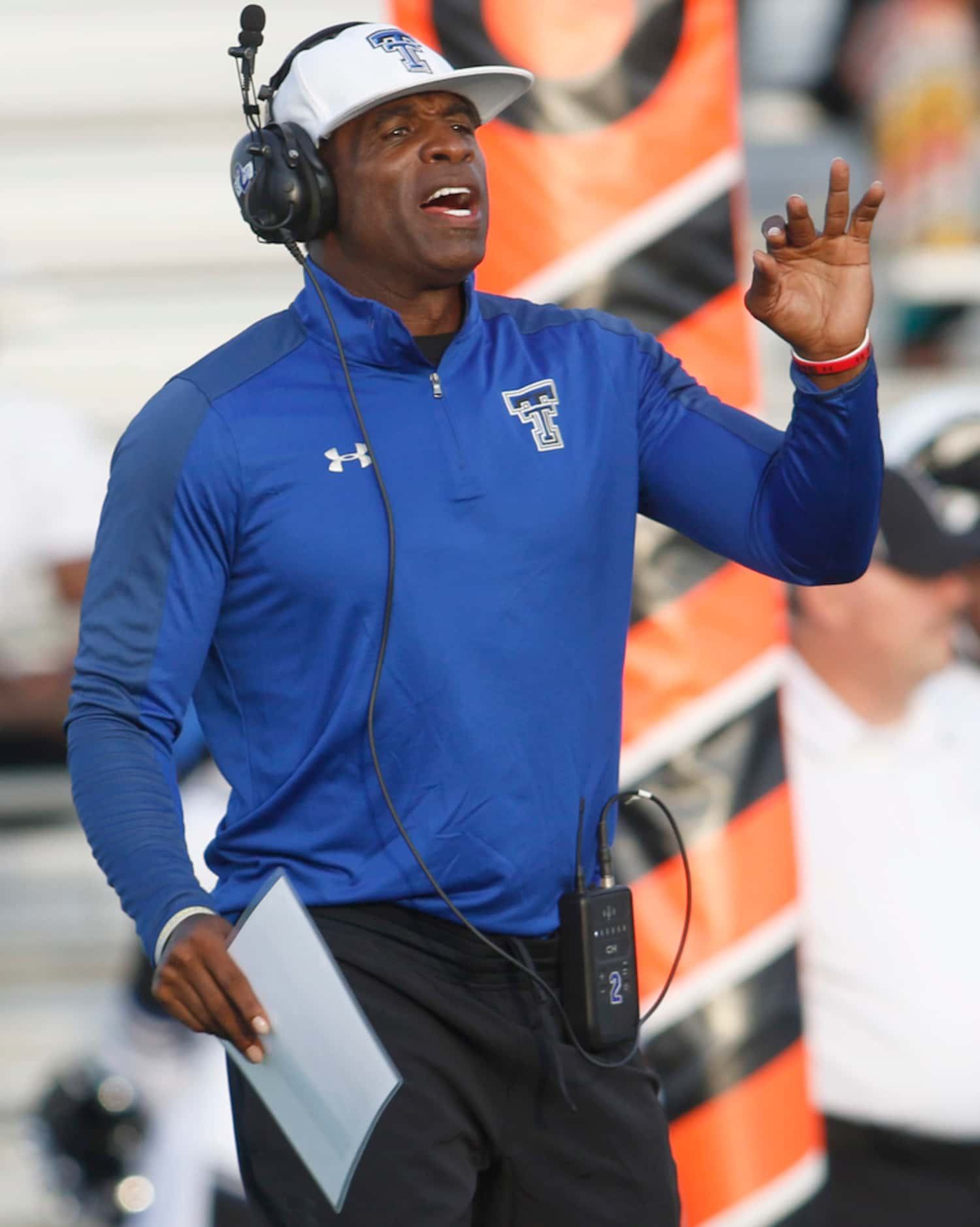 Trinity Christian-Cedar Hill offensive coordinator Deion Sanders sends in a play during...