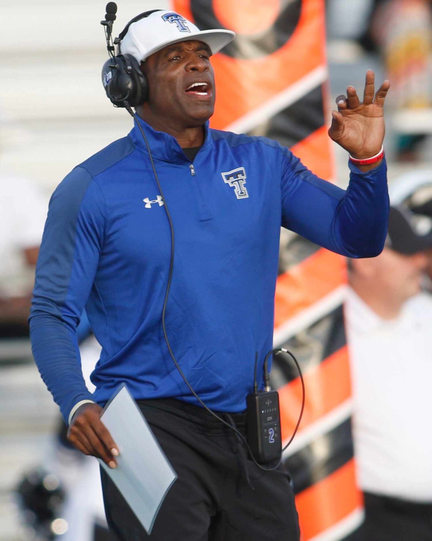 Trinity Christian-Cedar Hill offensive coordinator Deion Sanders sends in a play during...