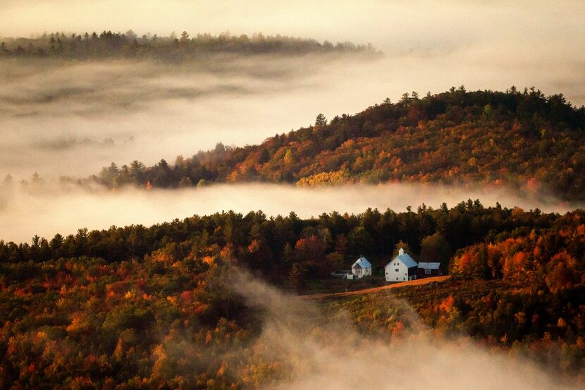 Valley fog wafts through the autumn-colored hills near the Picket Hill Farm, Oct. 13, 2021,...