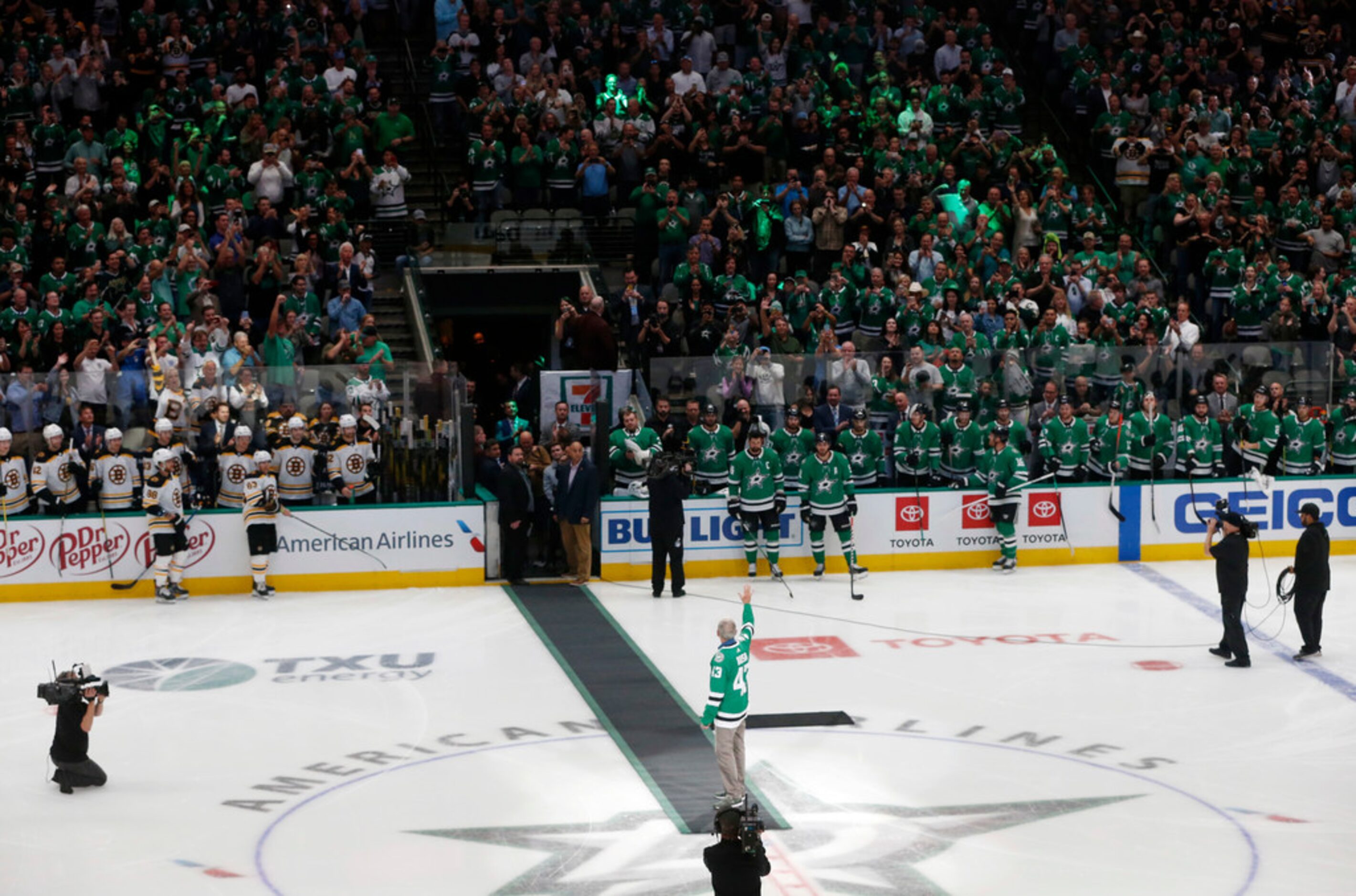 Former President George W. Bush waves to the fans before dropping the puck before a game...