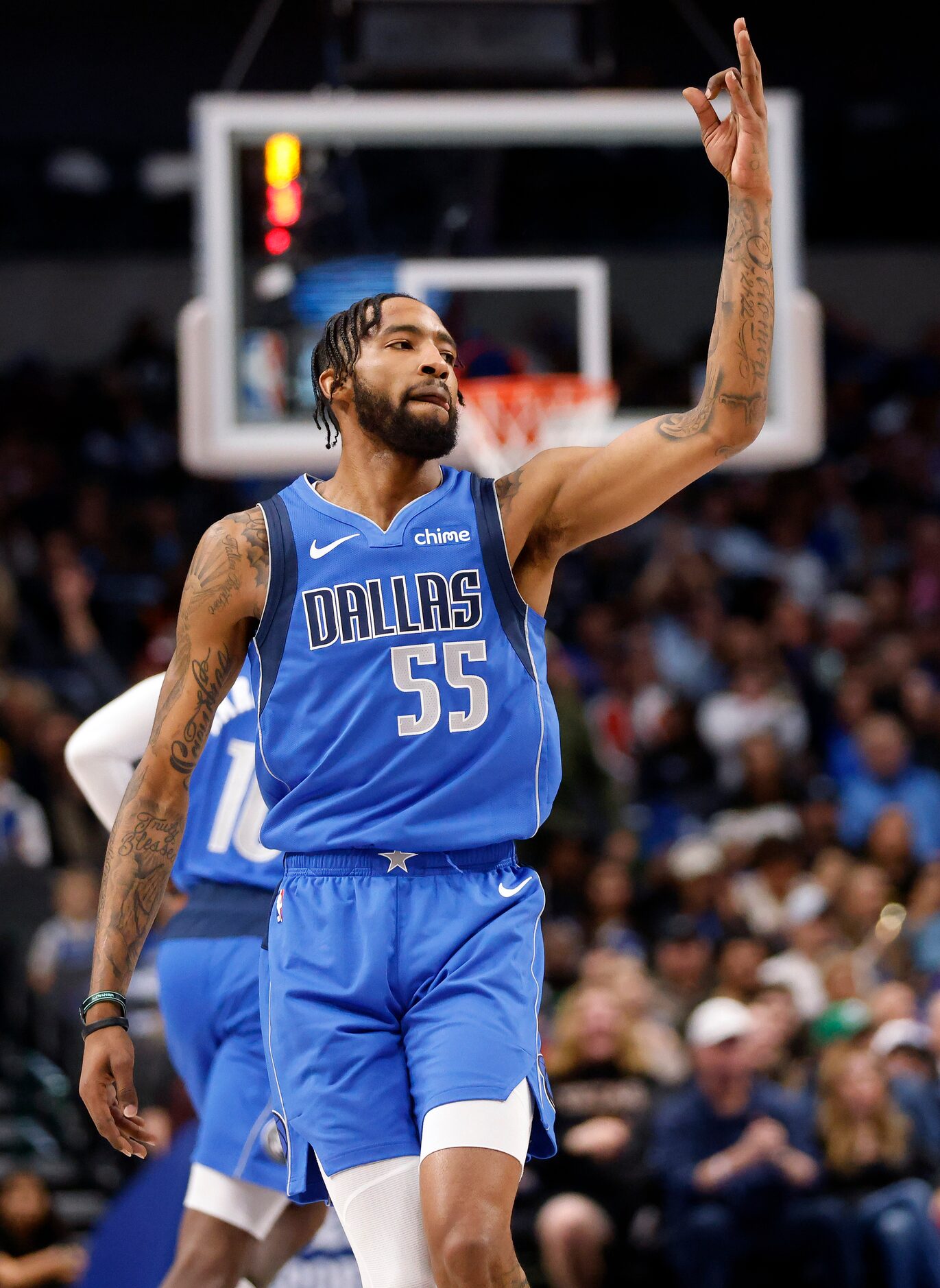 Dallas Mavericks forward Derrick Jones Jr. (55) throws up three fingers after hitting a...