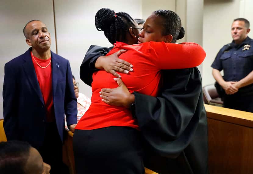 Allison Jean hugged state District Judge Tammy Kemp while her husband, Bertrum Jean, stood...